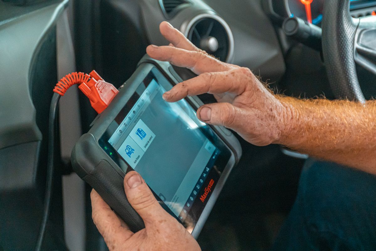 Técnico utilizando un escáner de diagnóstico dentro de un vehículo