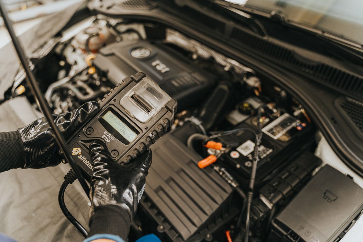 Mecánico comprobando el motor con una herramienta de diagnóstico